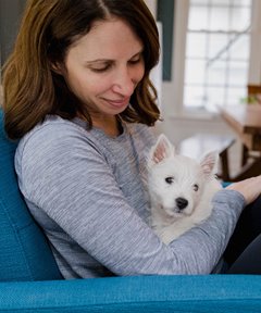 image of a woman hugging a dog on a couch