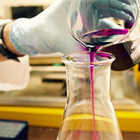 A scientist pouring liquid into a beaker