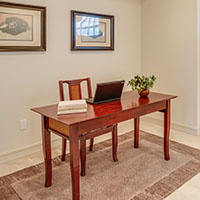 Desk with chair, computer, books, and a plant