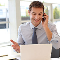 Man talking on phone with computer
