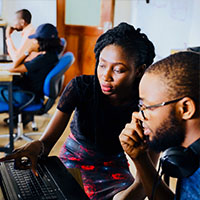 Woman helping man on computer