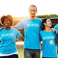 Group of people wearing blue shirts that say volunteer